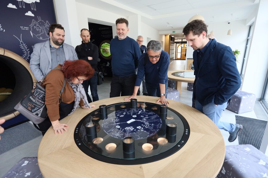 Návštěvníci si prohlížejí interaktivní stůl v Domu přírody Bílých Karpat.