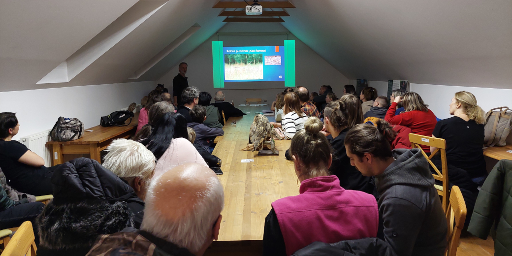 Účastníci poslouchají přednášku o sovách v prostorách terénní stanice Správy CHKO.